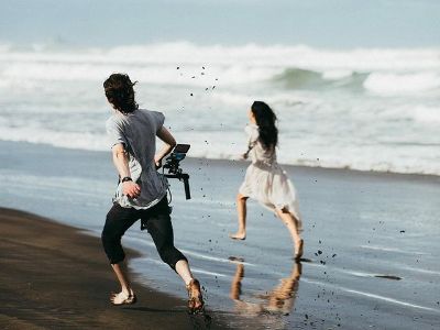 Erana James is running on the beach as the cameraman is recording the scene.